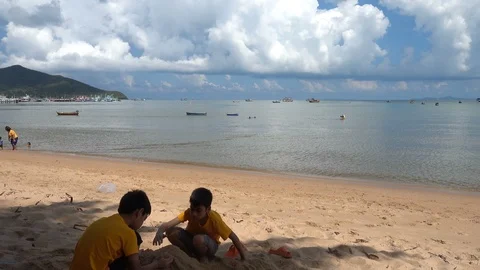 Little sibling boy playing sand on the beach summer time Stock-Footage 89755600