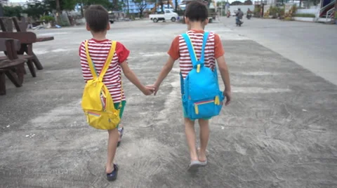 Little sibling boy walking on side walk going to school Stockbeeldmateriaal 65800137