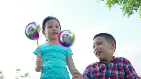 Little siblings playing with hand mill toy Stock Footage 86892889