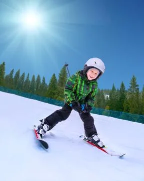 Little skier going down from snowy hill Stock Photos