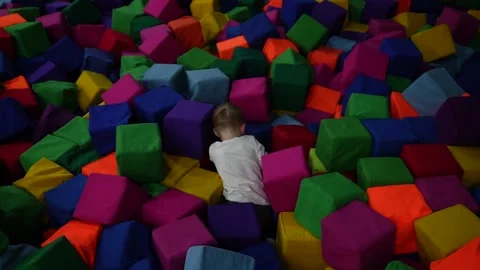 A little smart boy in large soft multi-colored cubes Stock Footage 220734530