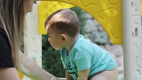 Little smiling boy playing with his mom on the playground Vídeo Stock 253288621