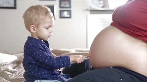Little son is touching belly his pregnant mom. FULL HD. slow motion Stock Footage 73962671