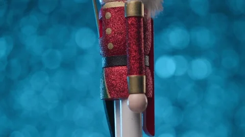 Little statuette of the Nutcracker is spinning on a cool blue bokeh background Vídeos de archivo 321680712