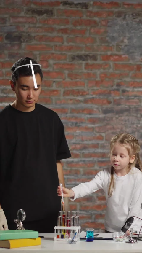 Little student does test with liquids under tutor control Stock Footage 310863591