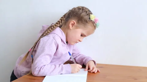 Little student doing homework while sitting at the table Video stock 147239546