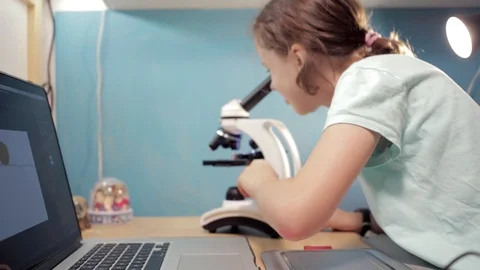 Little student girl learning using laptop and microscope. Video stock 90912007