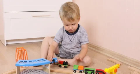 The little toddler boy using imagination to assemble toy train Stock Footage 96213313