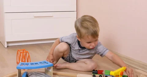 The little toddler boy using imagination to assemble toy train Stock Footage 96213404