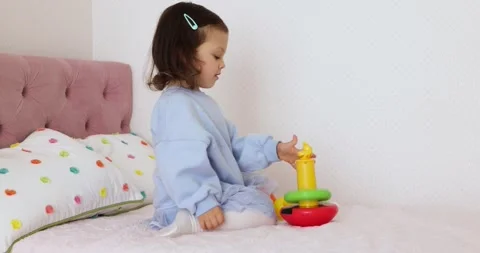 Little toddler kid develops playing with colorful pyramid Video stock 308639052