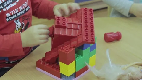 Little toddler plays with plastic constructor building house Stock Footage 194488457