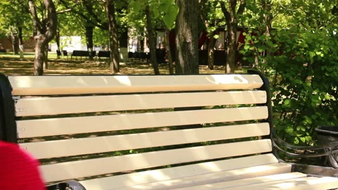 Little two year old child climbs on a bench, sitting on it. spring afternoon Stock Footage 90265167