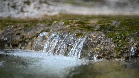 A little waterfall from a mountain stream creates bubbles (slow motion) Stock-Footage 219634935