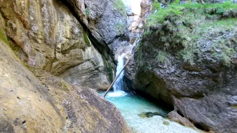 A little waterfall pouring down in the valley of the mountains in the alpes Stock Footage 157318328