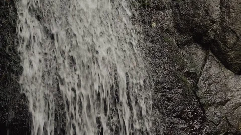 Little waterfall running down a flat rock closeup Video stock 119490176