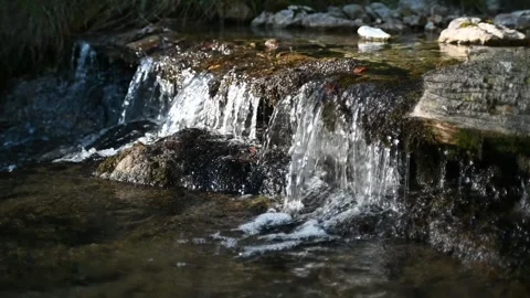 A little waterfall from a small brook in the evening sun (slow motion) Stock-Footage 260846424