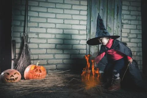 Little witch making a magic potion at Halloween night. Horror Stock Photos