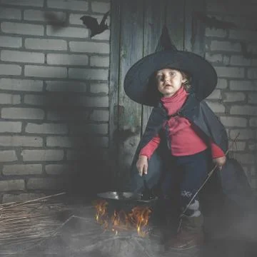 Little witch making a magic potion at Halloween night. Horror. Stock Photos