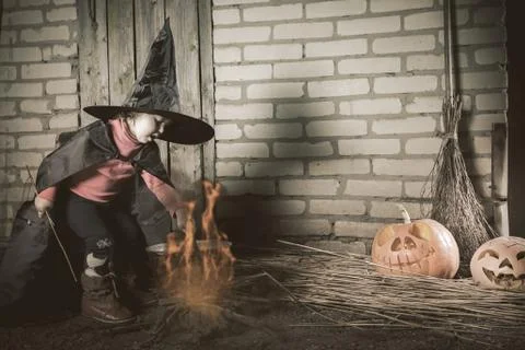 Little witch making a magic potion at Halloween night. Horror. Stock Photos