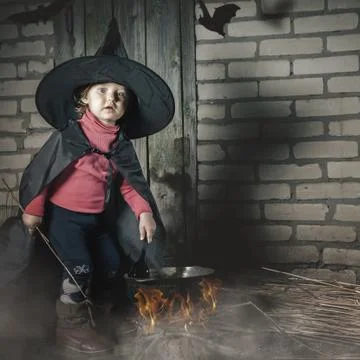 Little witch making a magic potion at Halloween night. Horror. Stock Photos