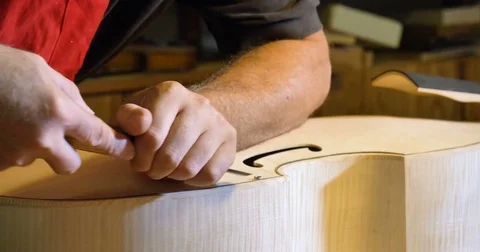 a liutist while building one of his works. violin Stock Footage