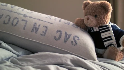 Live Animated Teddy Bear On A Bed Stretching By A Pillow 库存影片 117243587