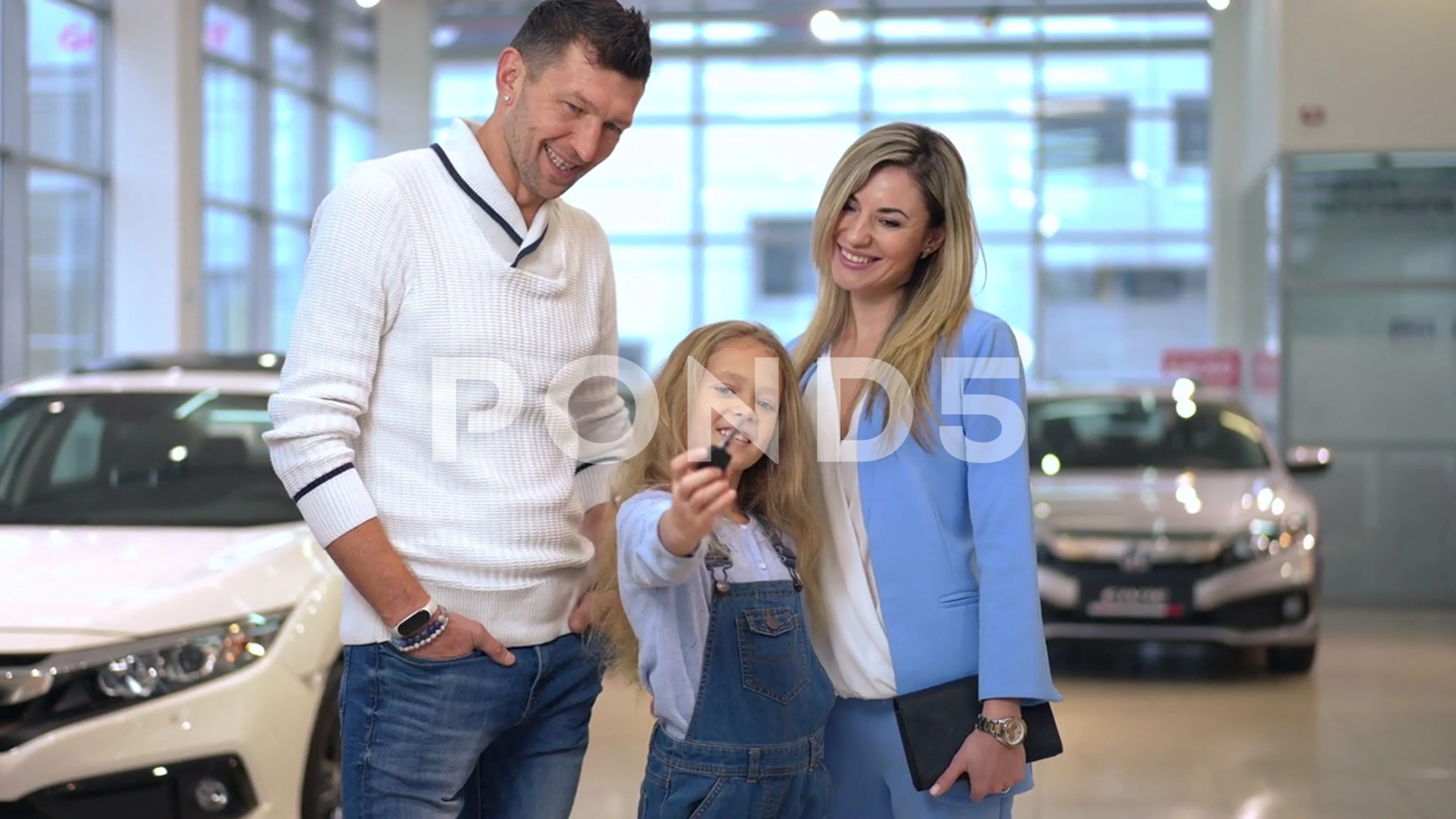 Live camera zoom in to happy girl showing car key smiling standing with  mother