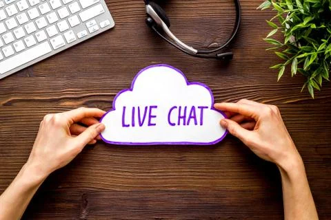 Live chat concept - bubble in hands on wooden table top view Stock Photos