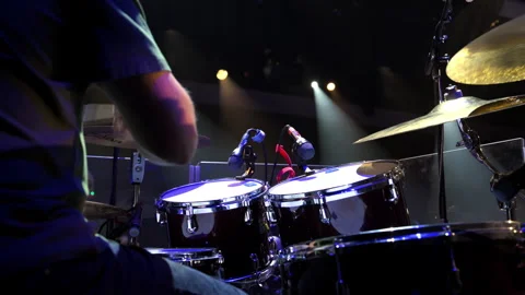 Live concert performance, a drummer energetically playing on stage under Stock Footage 318048926