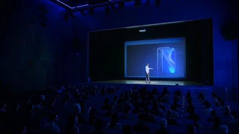 Live Event with New Products Launch: Keynote Speaker Reveals Smartphone Device Stock Footage 126502296
