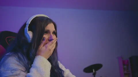 Live streamer wearing headset showing disappointment after negative feedback Stock Footage 307459397