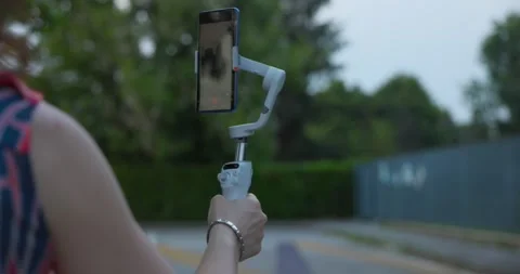 Live streaming outdoors with Osmo Mobile gimbal stabilizer and smartphone Stock Footage 247115266
