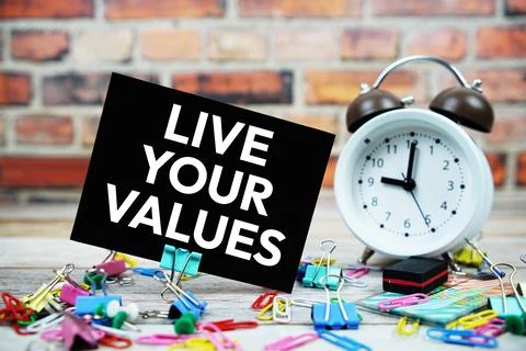 Live Your Values text on paper card with alarm clock and stationary on wood.. 스톡 사진