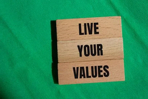 Live your values words written on wooden blocks with green background. Concep 写真素材