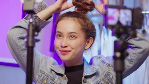 A lively beauty tutorial showcasing an influencer styling her hair against a Stock Footage 297441473