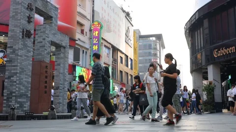 Lively Beijing Lu with shops. One couple inspects the monument 스톡 동영상 118664490