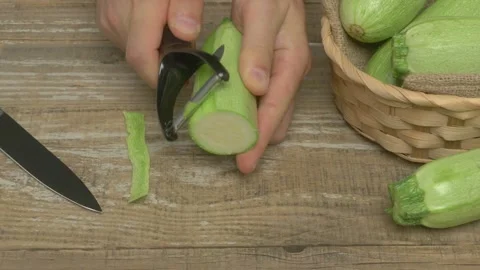 In a lively kitchen, fresh cucumbers are skillfully peeled for cooking and Vidéo 282516653