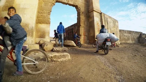 A lively movement of people next to the ancient stone large gates of the Stock Footage 81902092