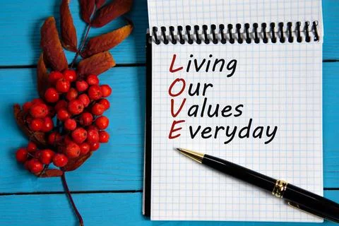 LIVING OUR VALUES EVERYDAY - words in a white notebook on a wooden blue backg Stock Photos