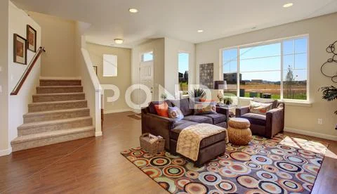 Living room with brown couch and cheerful rug Stock-Fotos