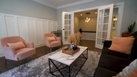 Living room with dark sofa, orange pillows, and french doors Stock Footage 345694952
