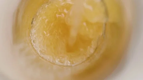 Llooking down into a beer pour in slow motion into a glass on a white cyc Stock Footage 70672601