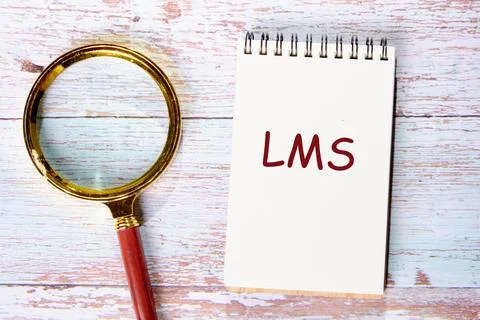 LMS - Learning Management System acronym. LMS in a notebook next to a magnify 스톡 사진