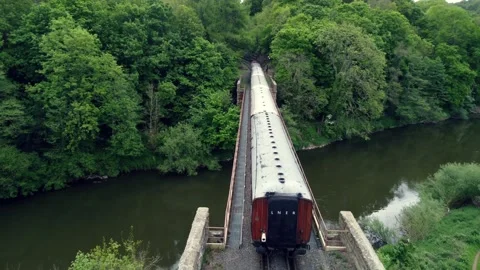 An LNER steam train on a railway through trees in England Vídeo Stock 196750253