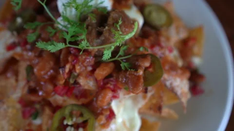 Loaded cheese and chilli nacho topping Mexican famous food 4k Stock Footage 309847913