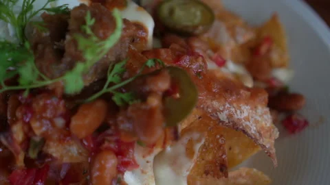 Loaded cheese and chilli nacho  taco topping Mexican famous food Stock Footage 309847923