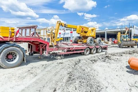 Loaded cherry picker and secured for transport on semi trailer Fotos de archivo