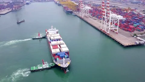 Loaded container cargo vessel traveling being assisted by tugboat docking on 스톡 동영상 336446145