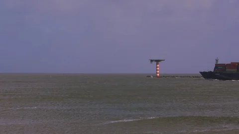 Loaded container ship leaving dock passing through choppy sea water Vídeos de archivo 115502524