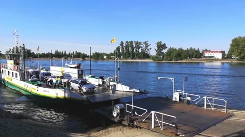 Loaded ferry approaches to river bank,docks at landing stage,people come ashore Stock Footage 130719543